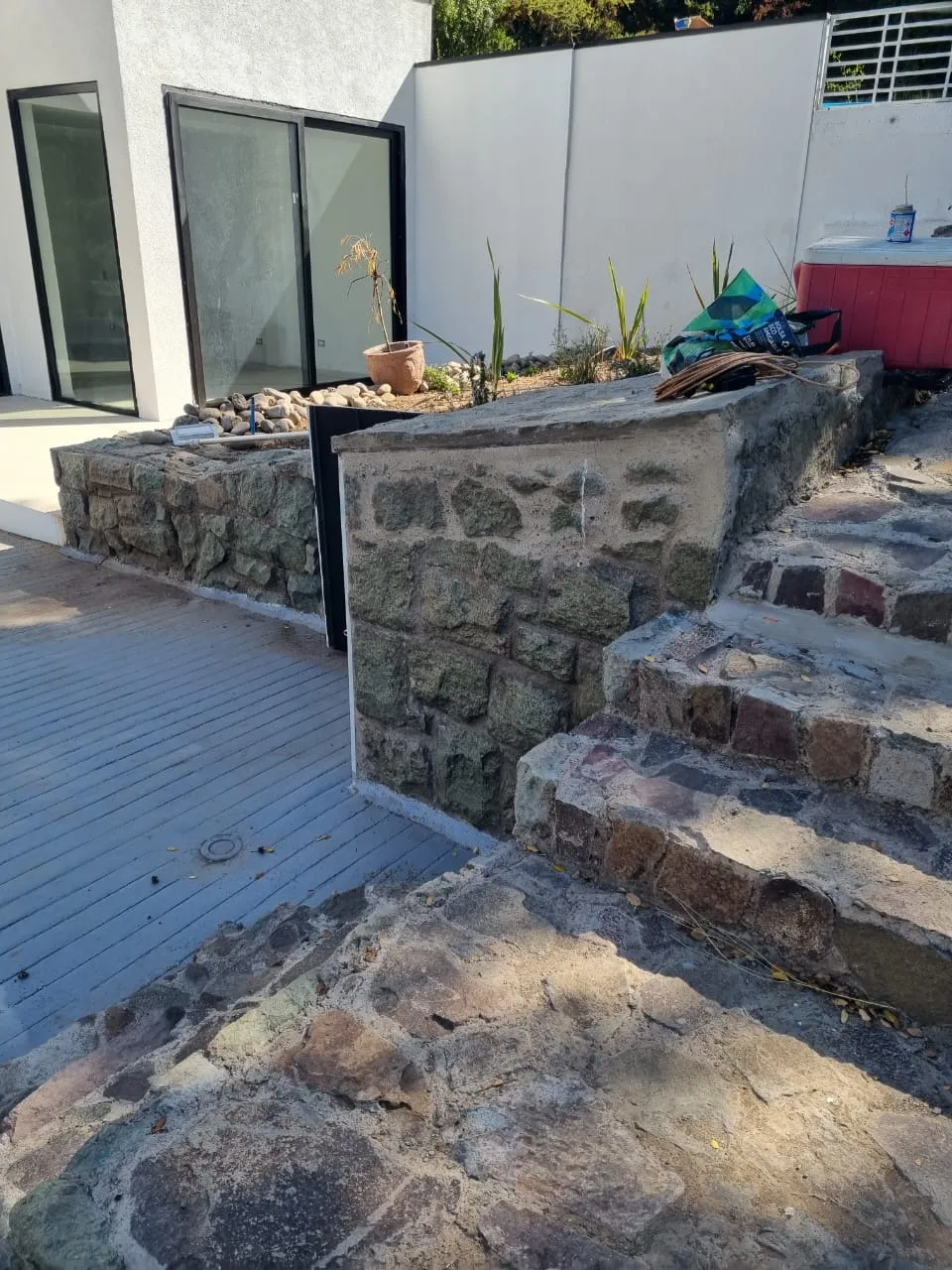 Escalinata de piedra rústica junto a deck de madera