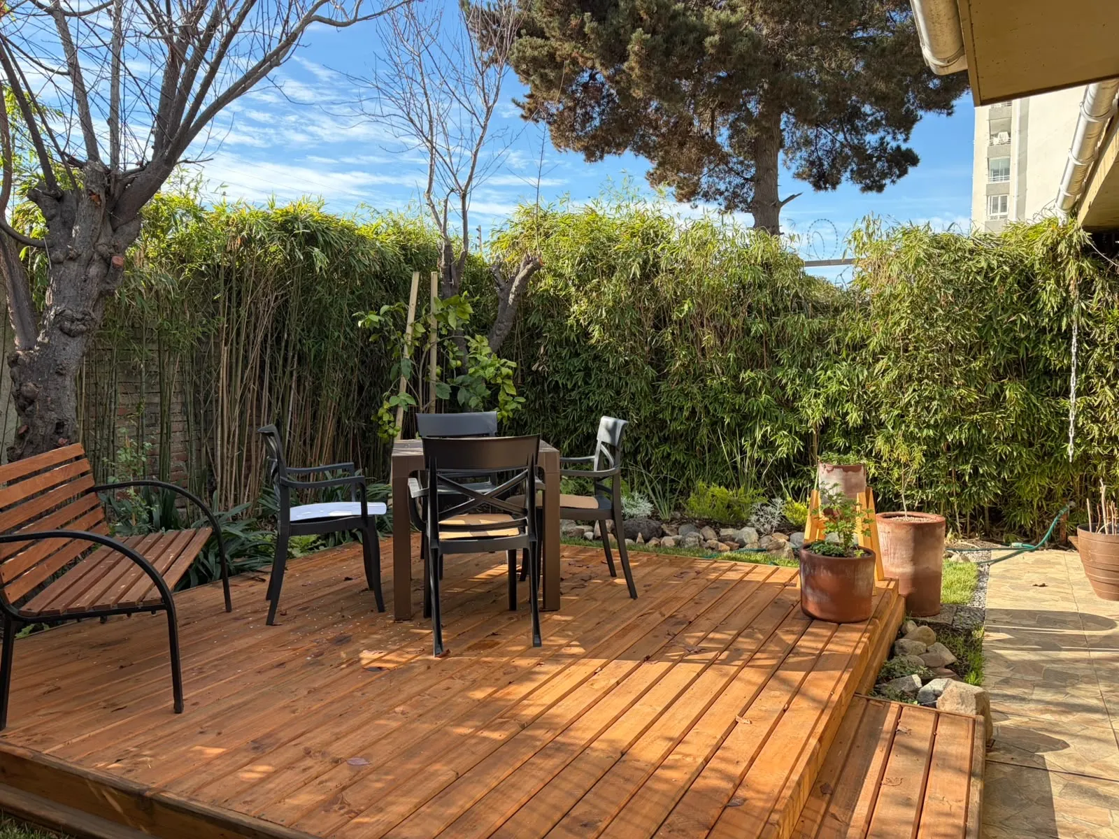 Deck de madera con pérgola y jardín perimetral en Curauma